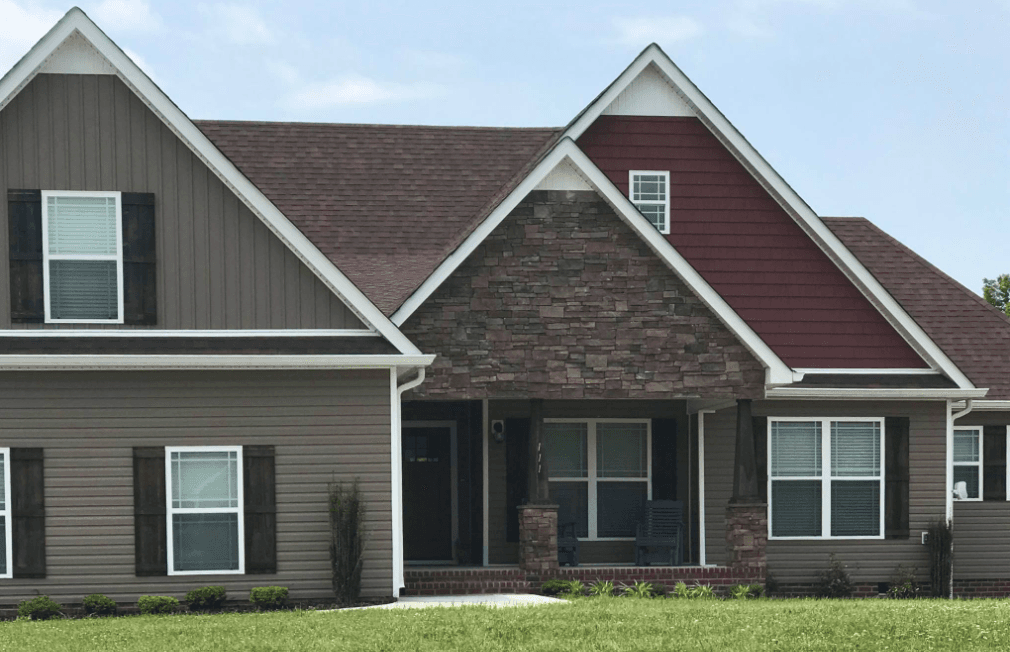Home with vinyl siding, stone accents, shake, and Board and Batten