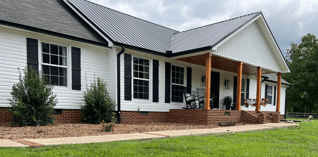 White home with new siding and black gutters